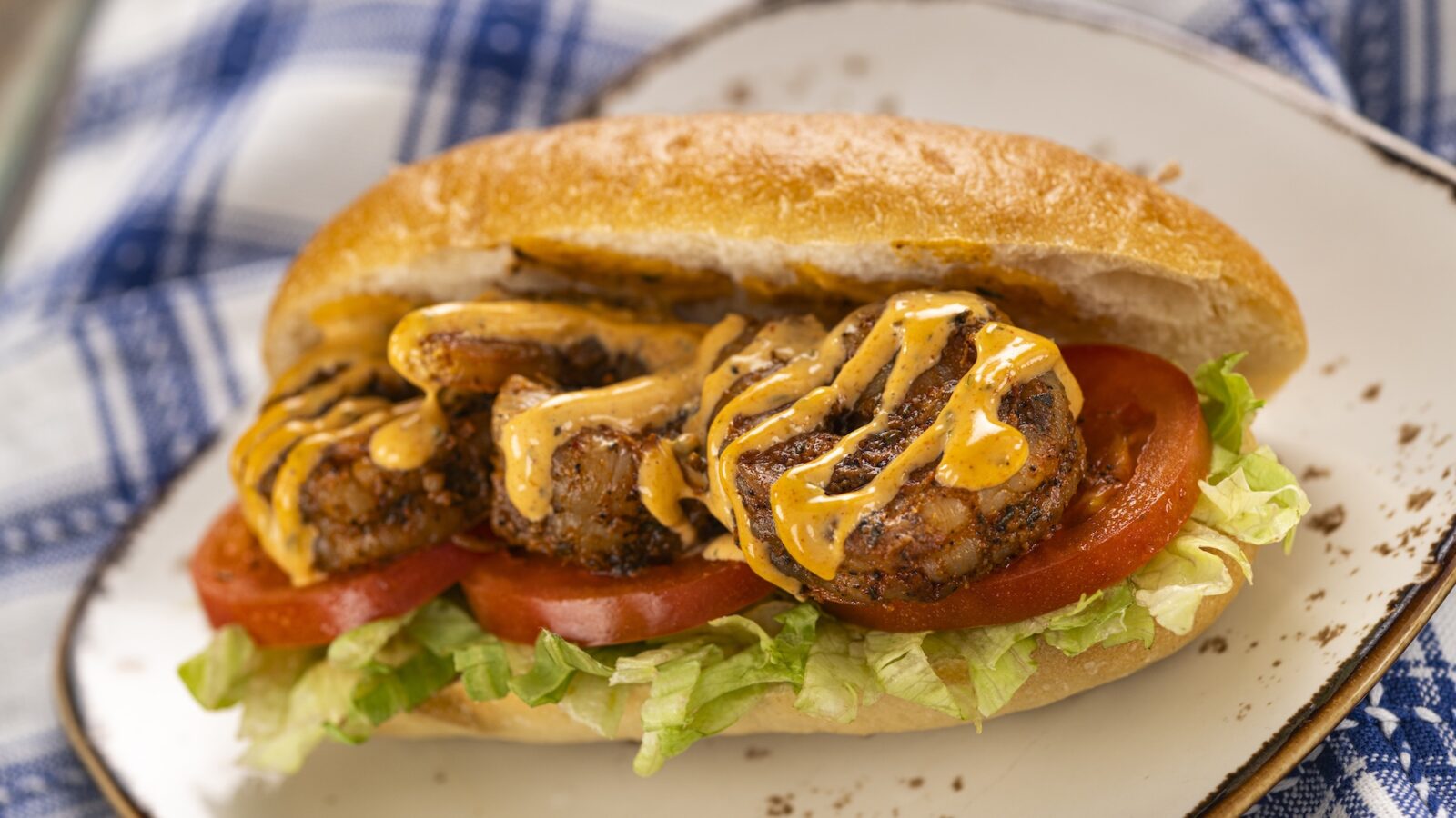 Blackened Shrimp Po Boy Magnolia Terrace American Adventure A classic Southern staple with a spicy kick topped with lettuce tomato and Cajun rémoulade