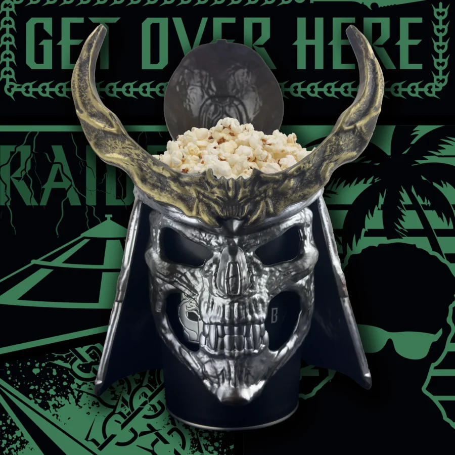Shiny skull helmet with large curved horns topped with popcorn set against a dark green gaming backdrop that reads Get Over Here