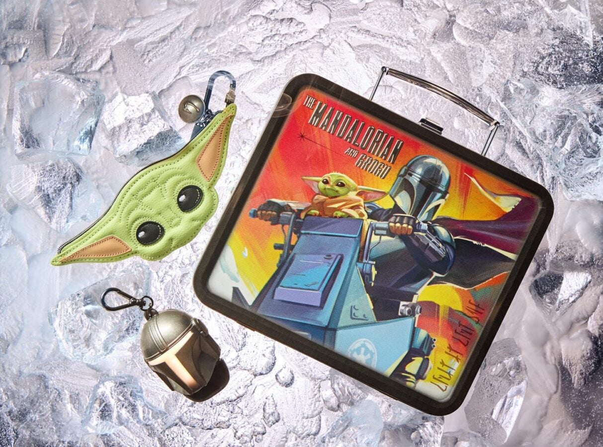 Lunchbox featuring The Mandalorian and Grogu artwork on a snowy icy surface with a green Grogu pouch nearby and a metal capsule keychain below it