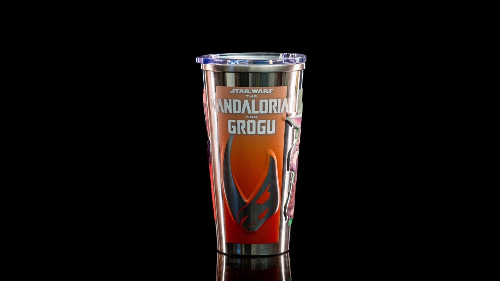 Stainless steel tumbler with Mandalorian and Grogu artwork and a clear lid on a black background