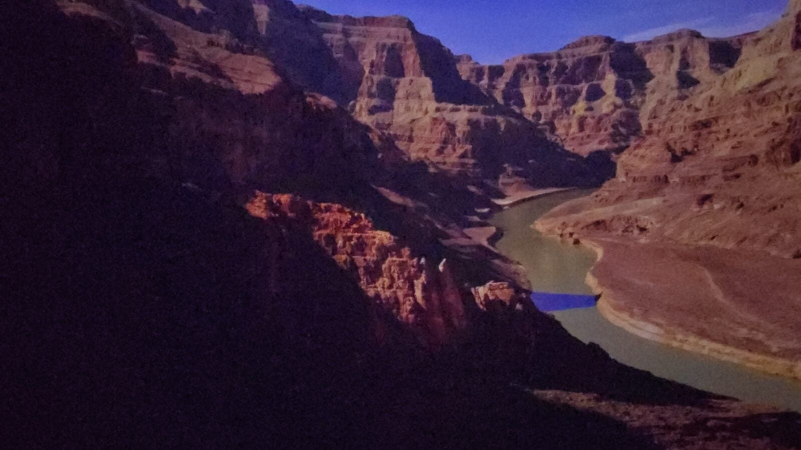 20260516102530 Fantasy Land News Twilight view of a deep canyon with layered red rock walls and a winding river at the base