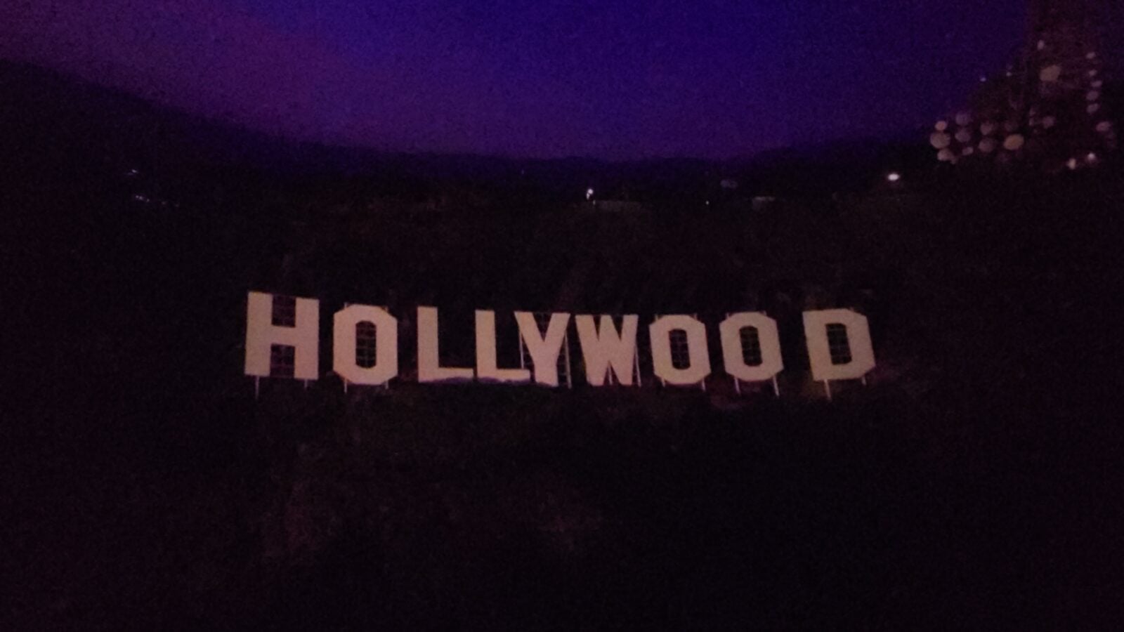 20260516102703 Fantasy Land News Hollywood sign on a hillside at night with a purple tinged sky in the background silhouettes visible