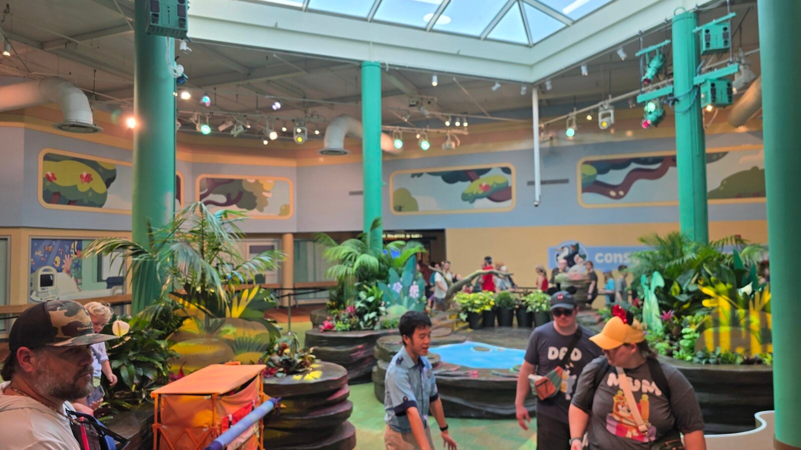 20260525105318 1 Fantasy Land News Indoor tropical themed entertainment space with green columns mural walls and visitors exploring around a small ride area