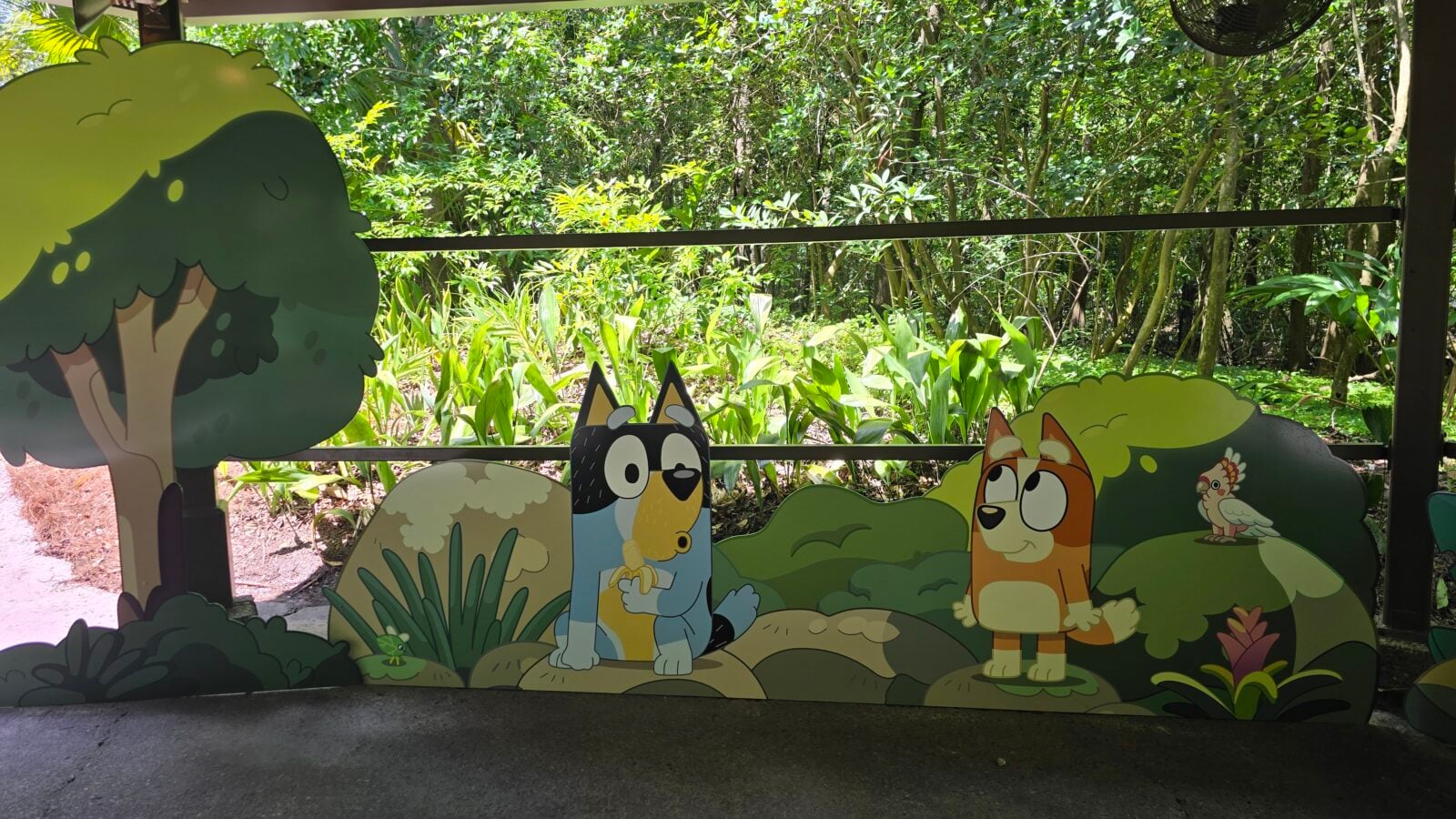 20260525115423 Fantasy Land News Playful cartoon animal cutouts along a decorative barrier in a sunny garden creating a kid friendly jungle scene