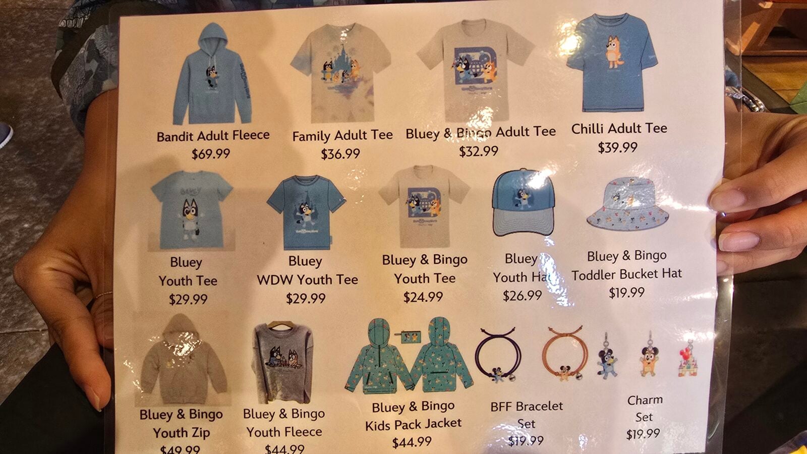 20260525123753 Fantasy Land News Catalog page displaying blue apparel and accessories hoodies tees hats and babykids items with Bluey characters and prices shown eg Bandit Adult Fleece Family Adult Tee