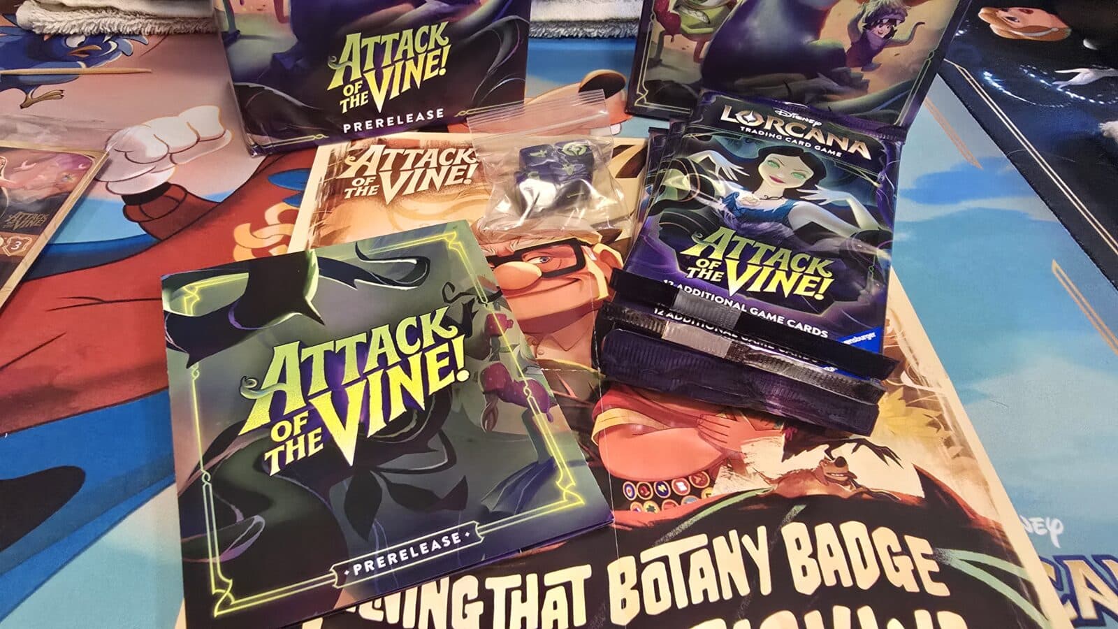 Pile of Lorcana Attack of the Vine booster packs and a few card sleeves on a colorful playmat