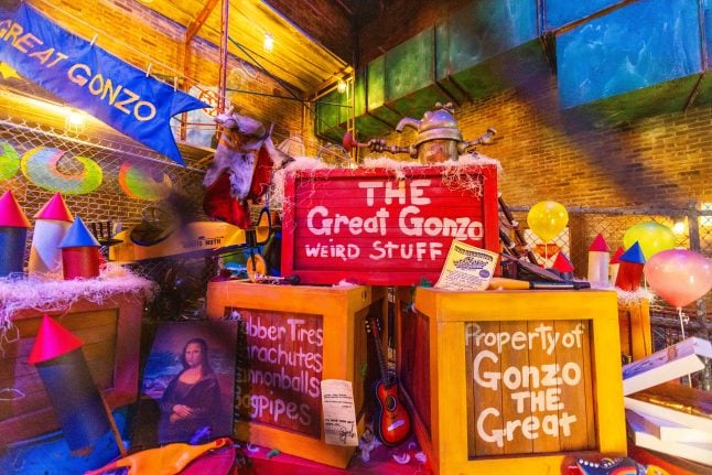 Colorful cluttered indoor display with bright signs The Great Gonzo Weird Stuff and Property of Gonzo the Great toys and props everywhere