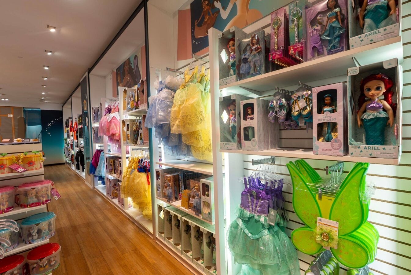 70467330417443815332071825662625671279656050n Fantasy Land News Toy store aisle with shelves of princess dolls and colorful dresses on display