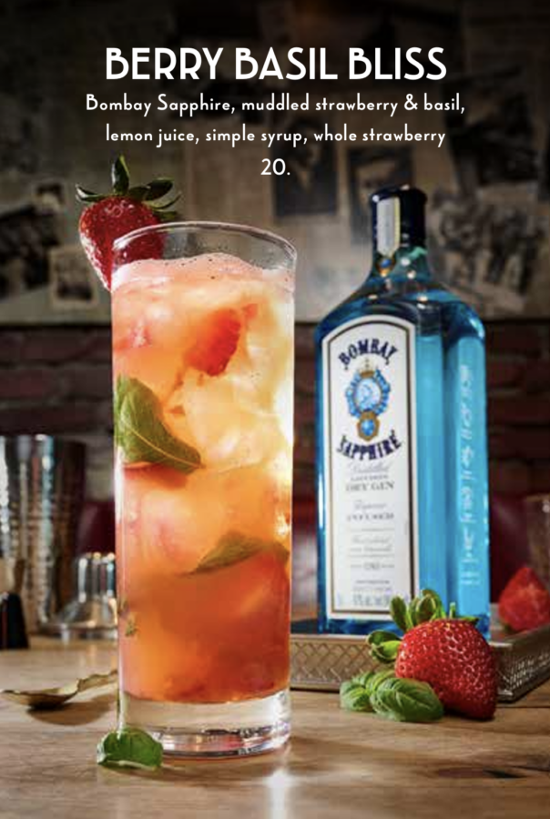 Berry Basil Bliss Fantasy Land News Tall glass of Berry Basil Bliss cocktail with strawberry garnish and a Bombay Sapphire bottle in the background