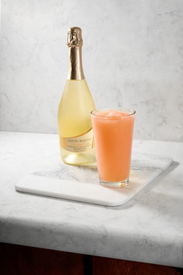 PatinaPizzaPontePeachBelliniwBottle 2 Fantasy Land News Bottle of sparkling Prosecco with a peach colored cocktail on a marble surface