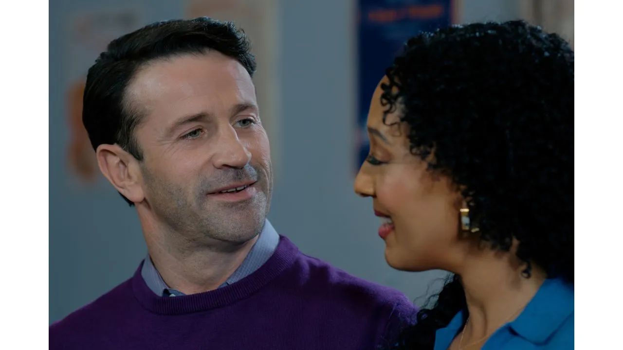 A man and a woman smile at each other while talking closely