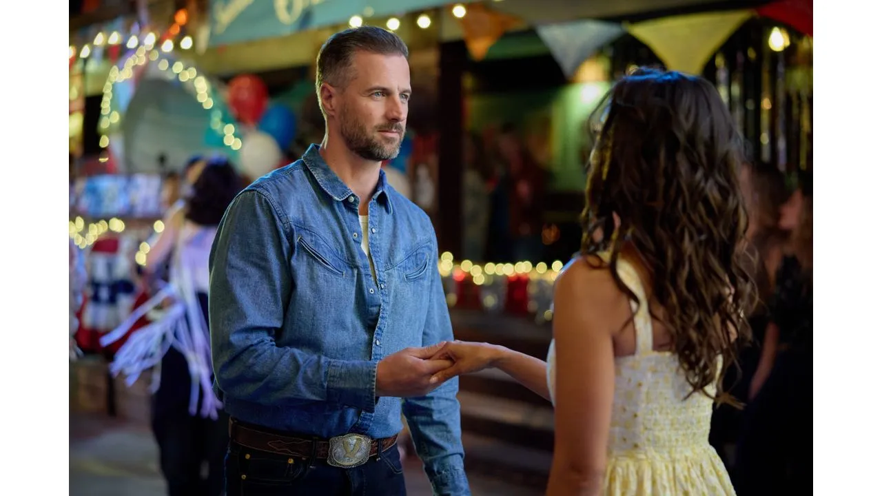 june6 Fantasy Land News Man in a denim shirt holds hands with a woman in a yellow dress at a festive lantern lit night market