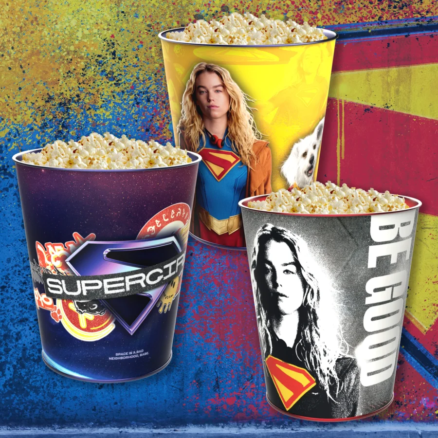 Bright promotional image with oversized popcorn tubs featuring superhero logos and a womans image on a yellow tub against a colorful splash background popcorn overflowing