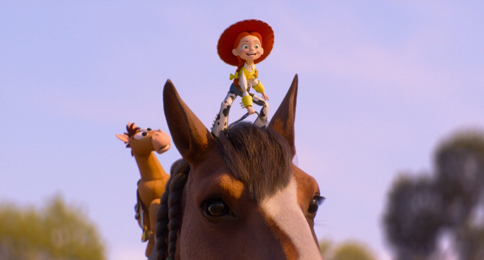 Jessie toy riding on a horses head against a clear blue sky during a parade or outdoor event