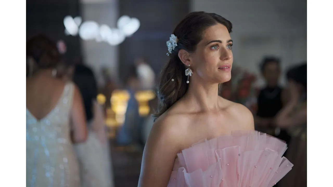 loveheist2 Fantasy Land News Woman in a pale pink ruffled off shoulder dress at a formal event looking to the right with a floral hair accessory and dangling earrings