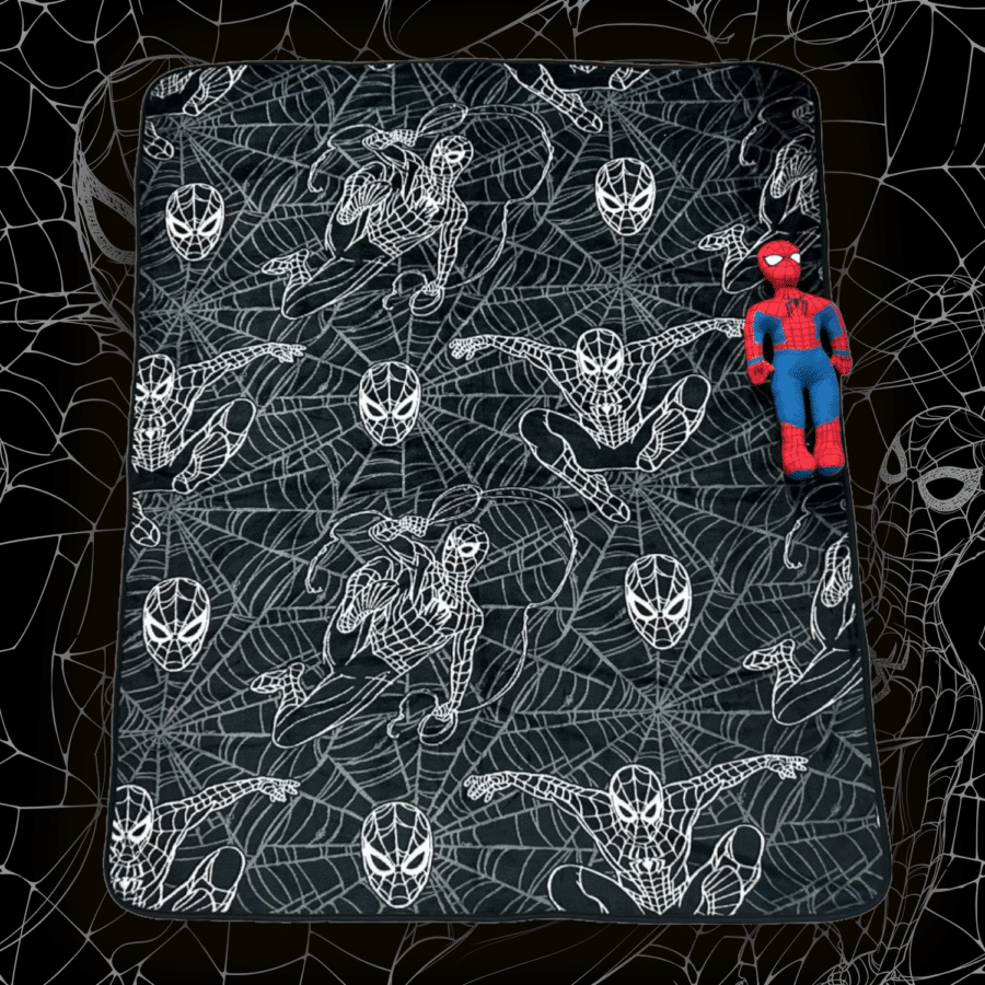 Dark bedspread covered in white Spider Man poses and web patterns with a red and blue Spider Man plush attached to the corner