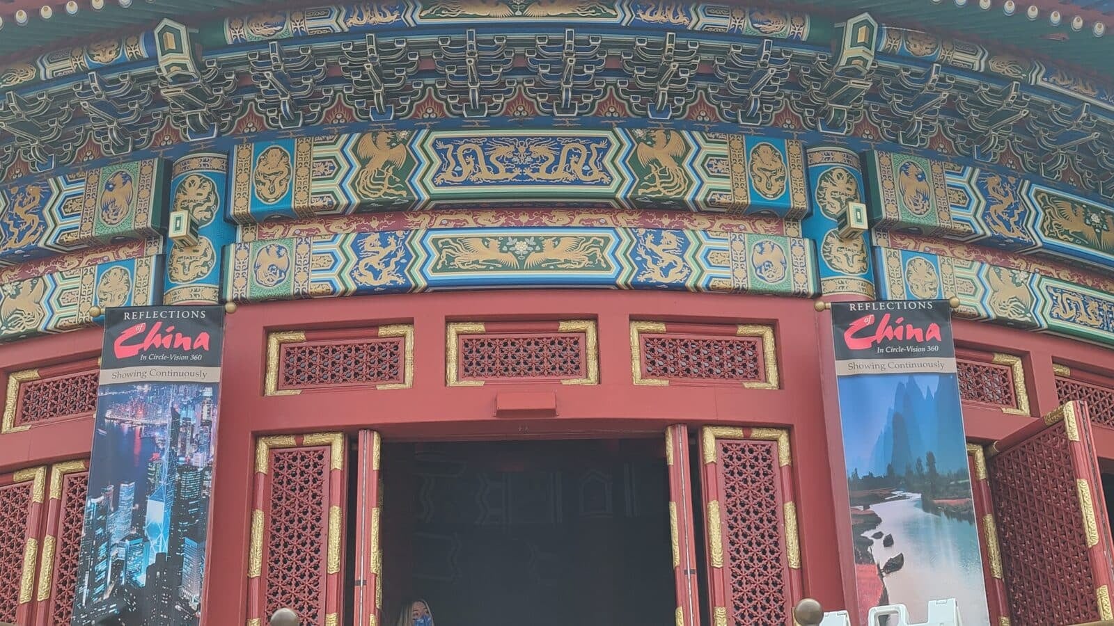 Colorful ornate Chinese temple facade with blue gold and red geometric patterns above red doors
