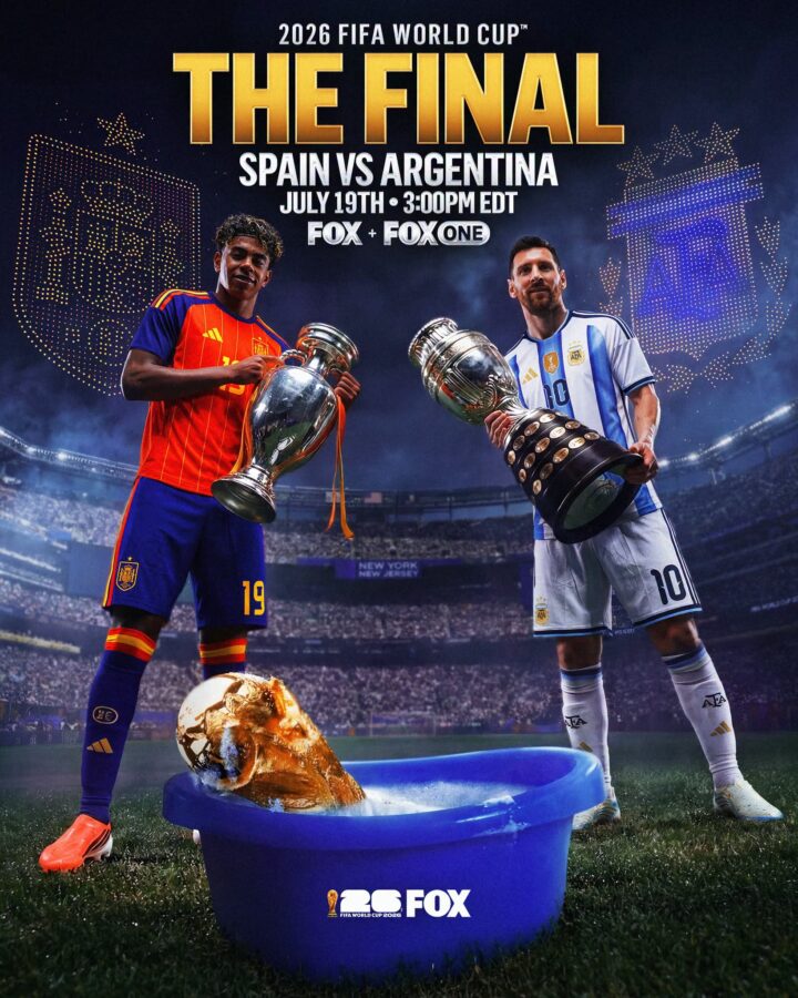 Two soccer players in Spain and Argentina kits hold large trophies in a stadium celebration a blue bucket at their feet with the 2026 FIFA World Cup FOX logo nearby