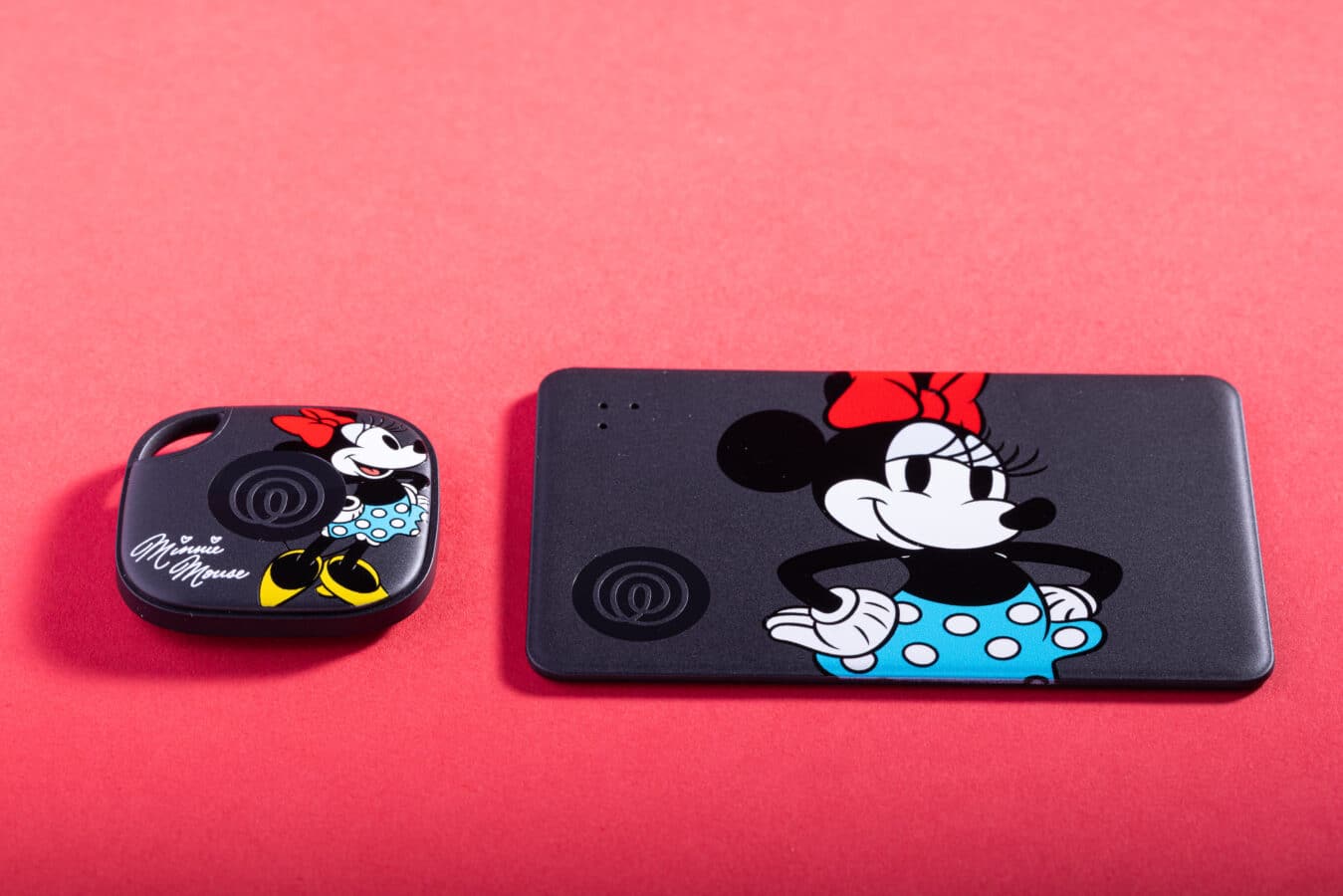 Two dark phone cases with Minnie Mouse artwork on a bright pink background a small square case left and a larger rectangular case right