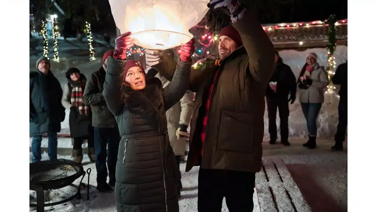 snowbound3 Fantasy Land News Couple releases a glowing sky lantern at a winter nighttime festival with onlookers and festive lights in the background
