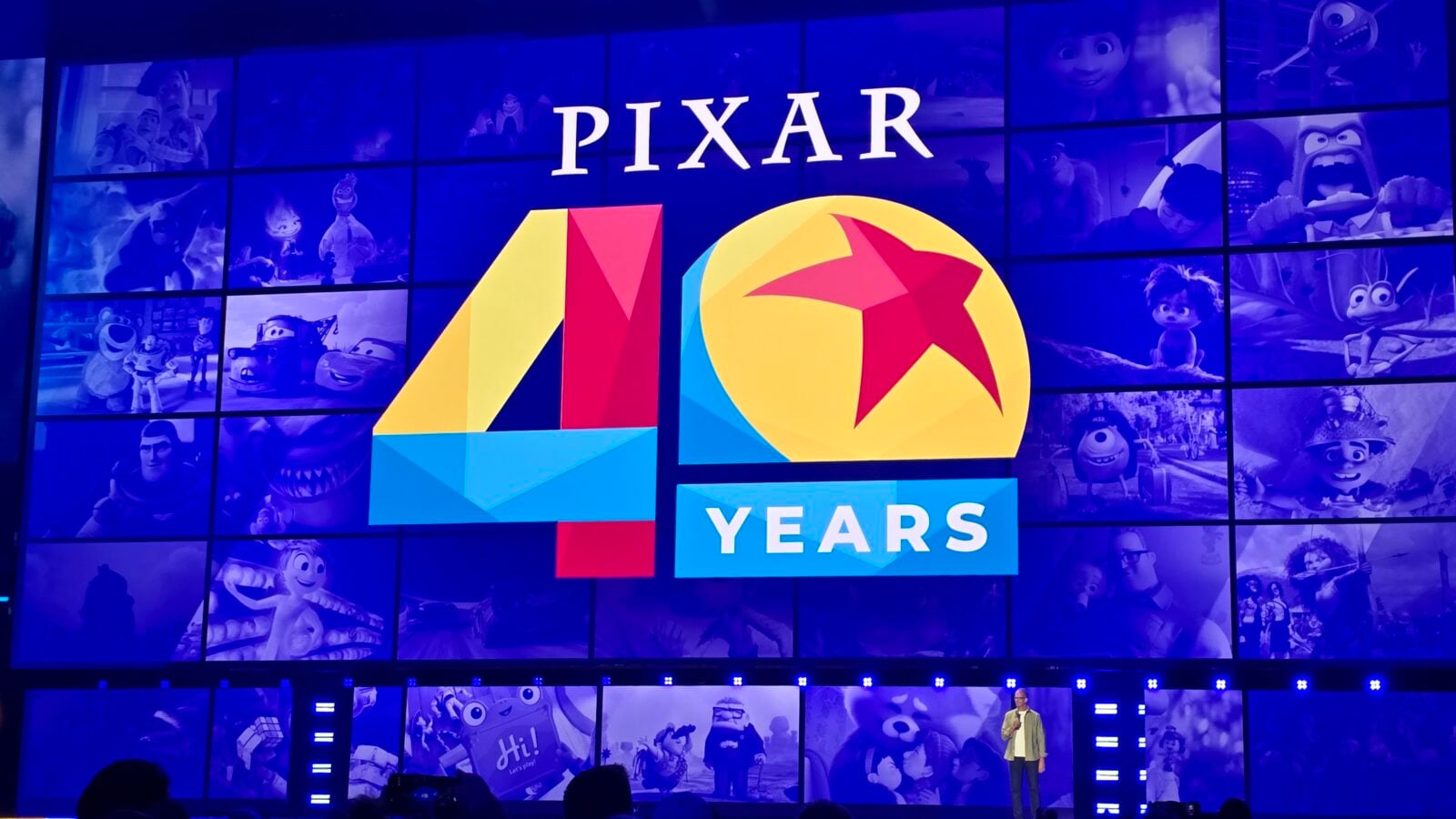 Pixar 40 Years banner with bold colorful 4 and 0 and star set against a blue collage of Pixar characters
