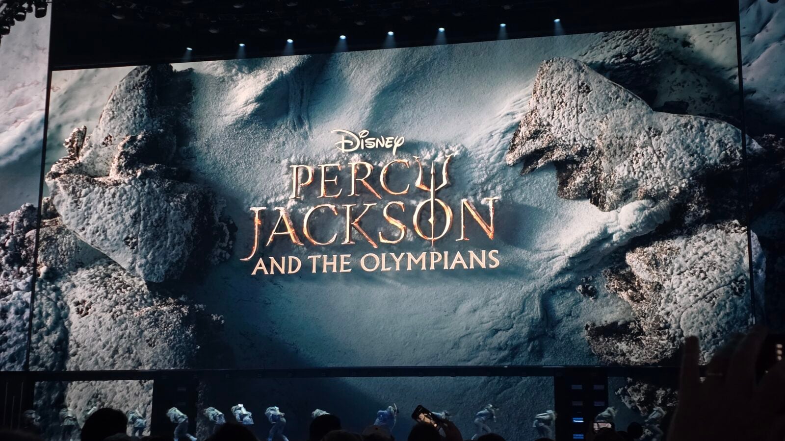 Promotional stage banner reading Disney Percy Jackson and the Olympians against a snowy rocky backdrop
