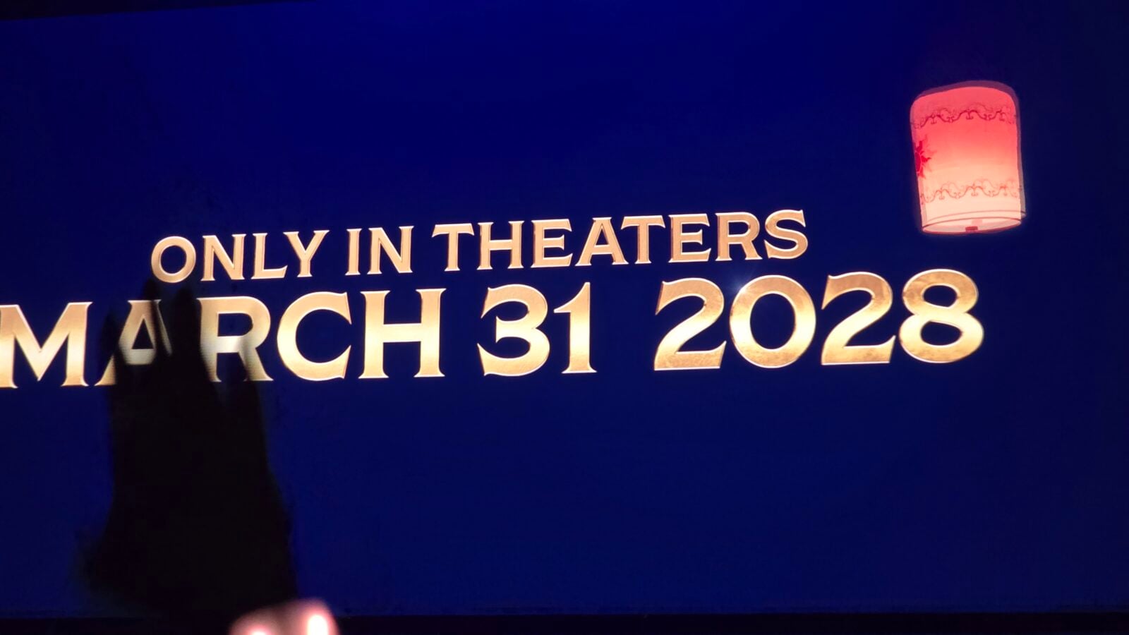 Blue banner with gold text reading'ONLY IN THEATERS' and release date 'MARCH 31, 2028'; a warm-lit lantern on the right side.