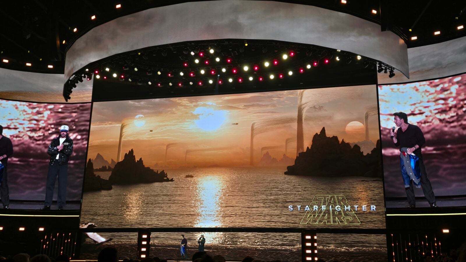 Stage with curved screens showing a sunset landscape from Star Wars performers on either side and the Star Wars logo visible at bottom right
