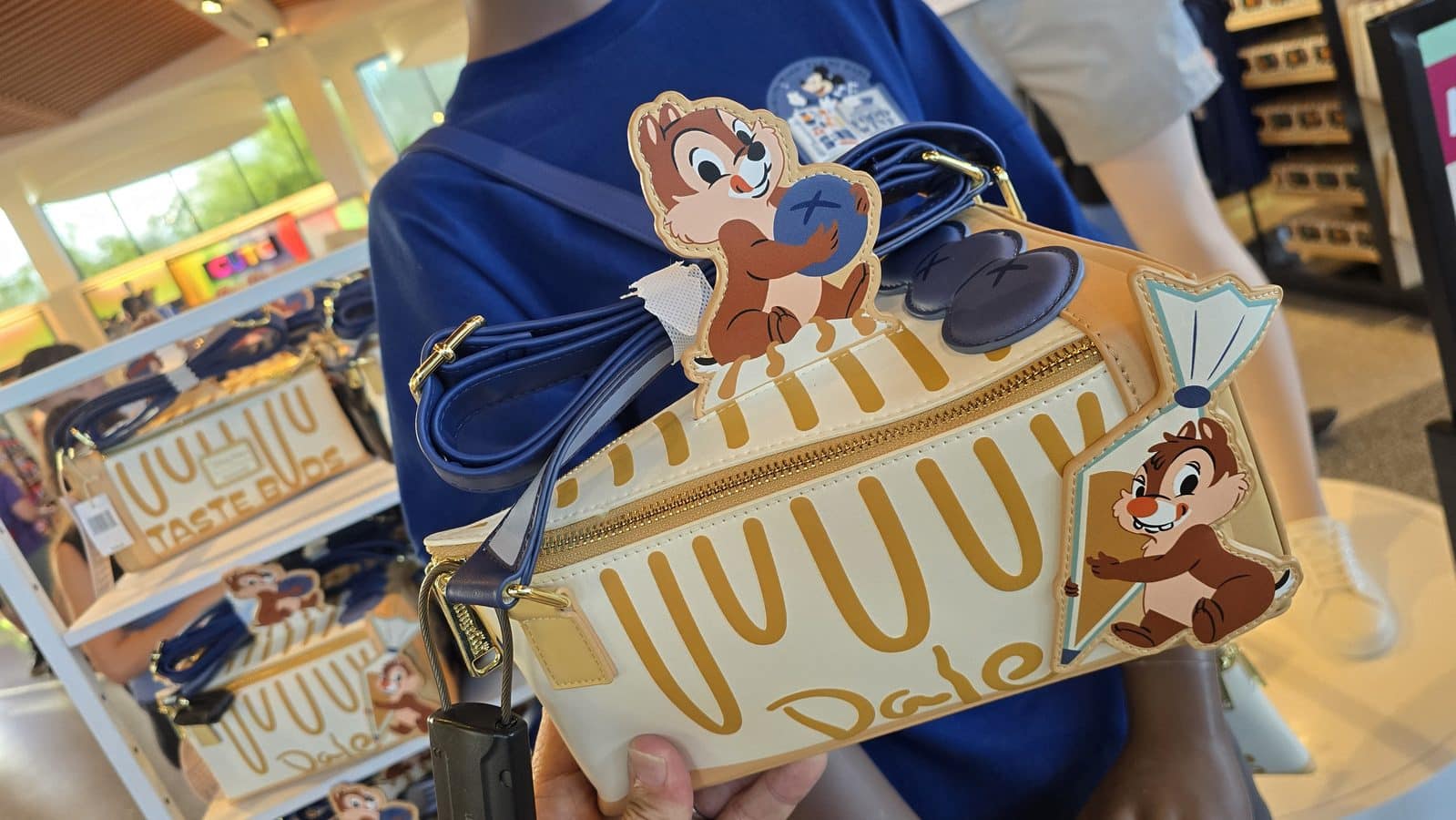 Disney themed tote bag with Chip and Dale cartoon cutouts and yellow stripes on display in a store