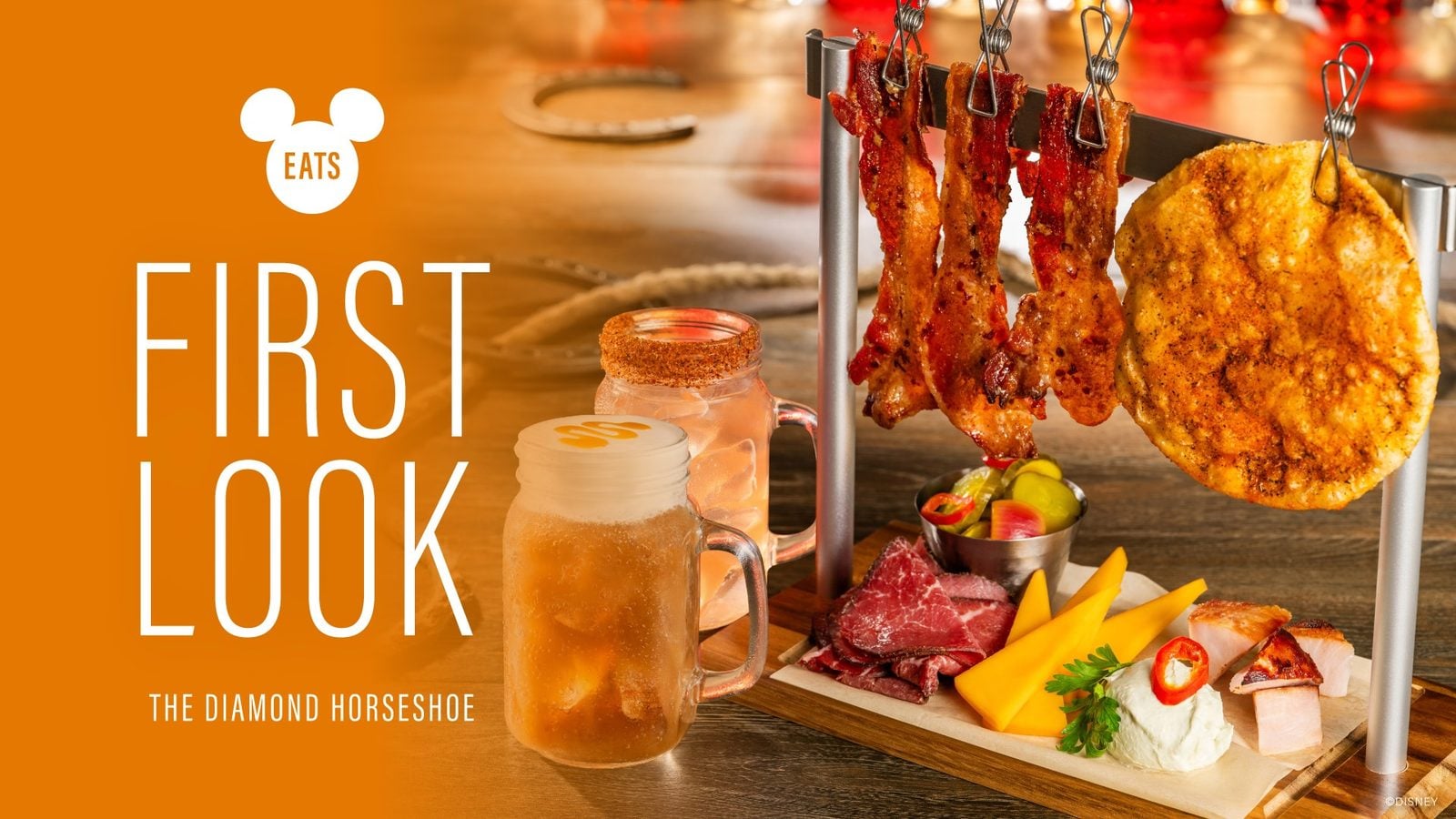 Magazine cover showing a meat and cheese board with skewers drinks and an orange left panel reading FIRST LOOK and a white EATS logo