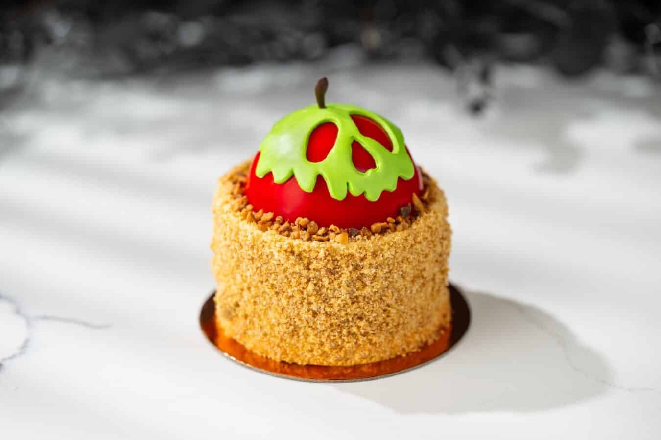 Mini cake with a red glossy dome and a lime green carved pumpkin top crumb coated sides