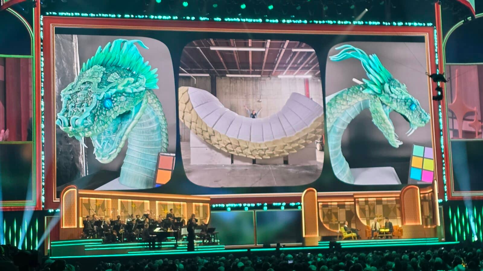 Teal dragon sculpture framing a concert stage with an orchestra performing below