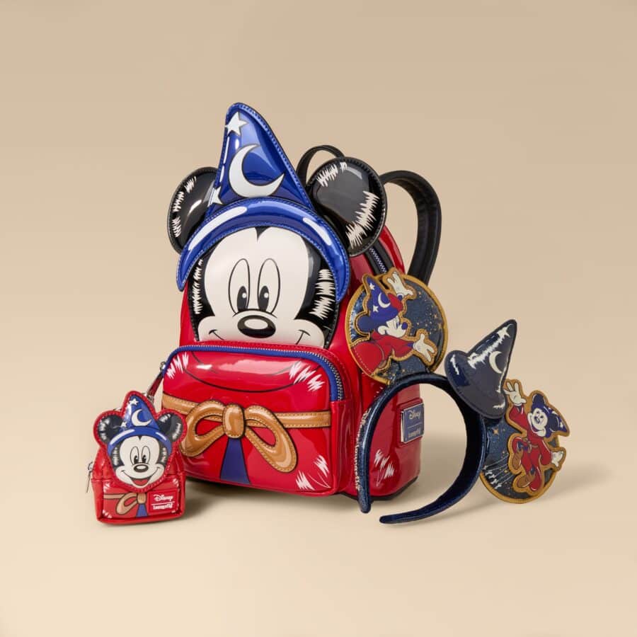 Stack of colorful Disney backpacks with Mickey Mouse faces and star patches on a beige background