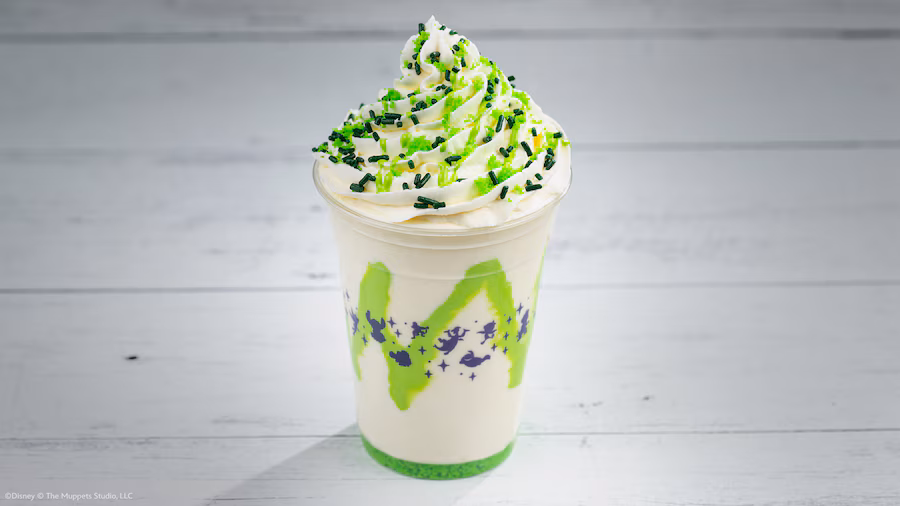 ThumbnailFB1920x1080 Fantasy Land News Vanilla milkshake in a clear cup topped with whipped cream and green and black sprinkles with a neon green logo on the side