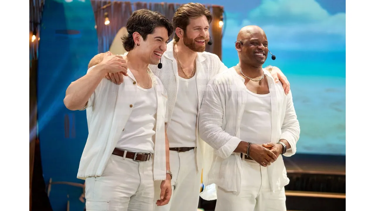 adty5 Fantasy Land News Three men in white outfits posing together on a stage smiling with arms around each other