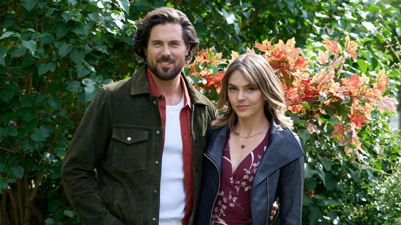 fall3 Fantasy Land News Man and woman standing together outdoors in front of green bushes smiling at the camera