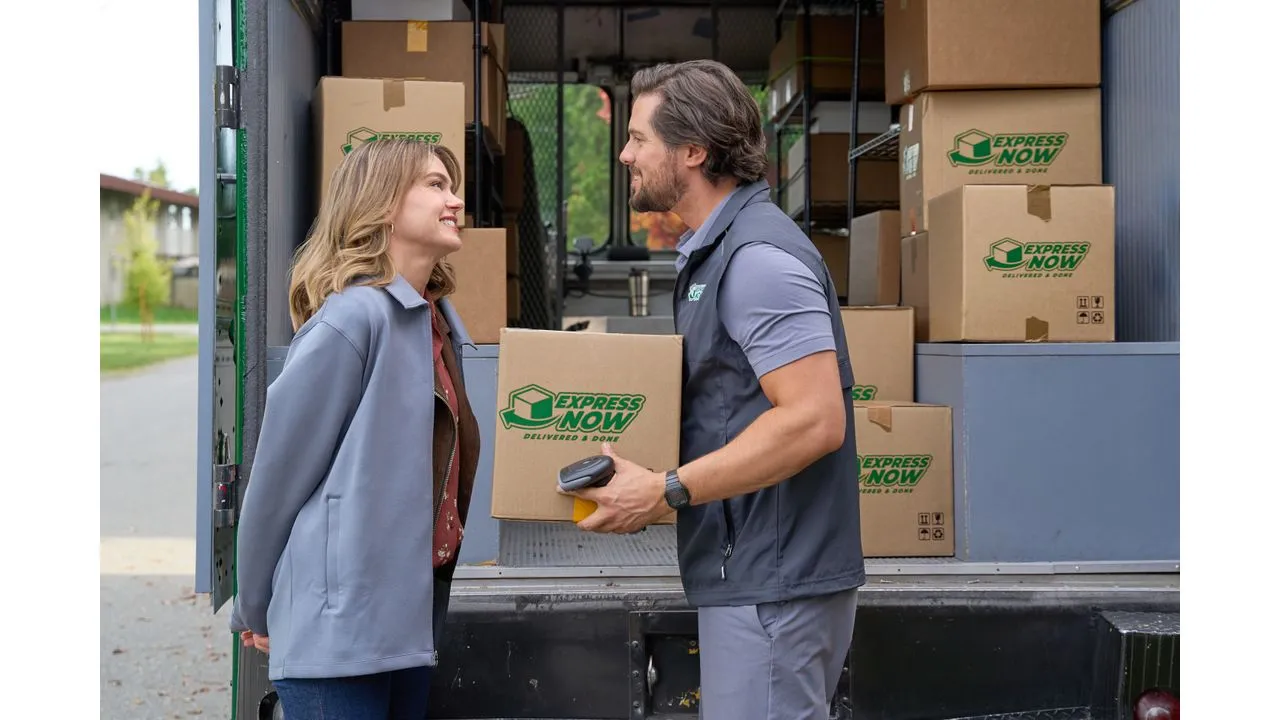 lovea Fantasy Land News Delivery driver hands a package to a customer beside an open delivery van filled with Express Now boxes