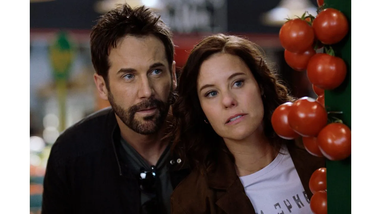 muchado5 Fantasy Land News Two adults a man and a woman leaning close together while looking at a cluster of tomatoes at a market stall