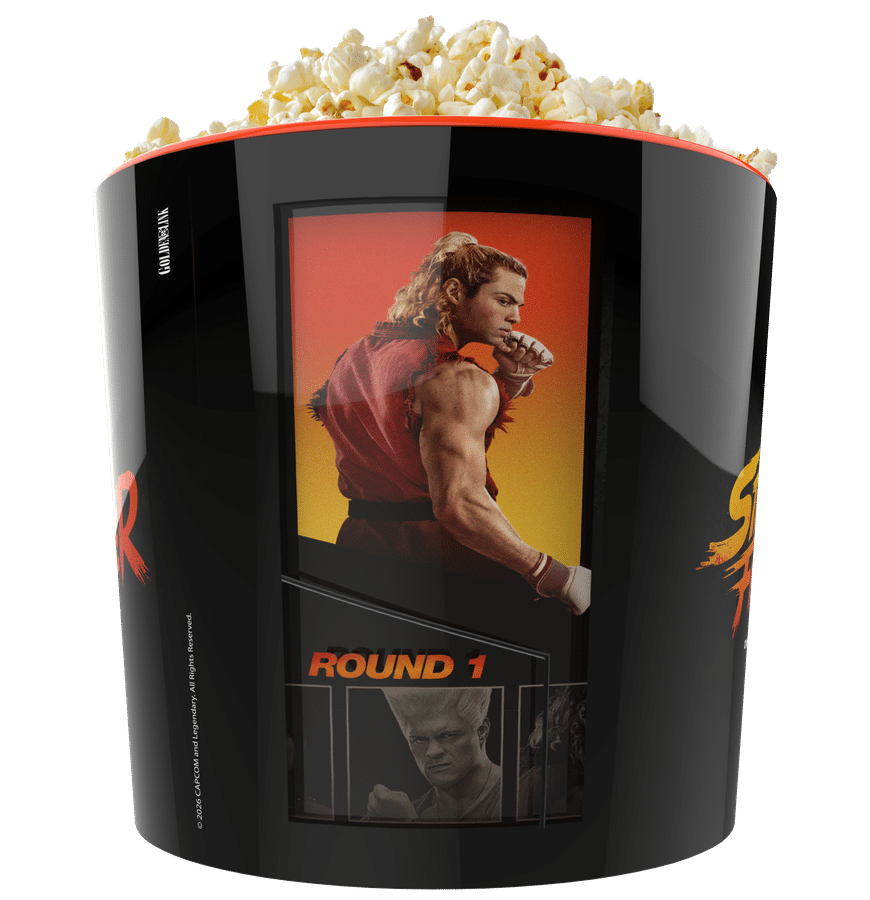 Popcorn overflowing from a glossy black popcorn bucket displaying a movie poster suggesting a cinema or movie night theme in a snack container