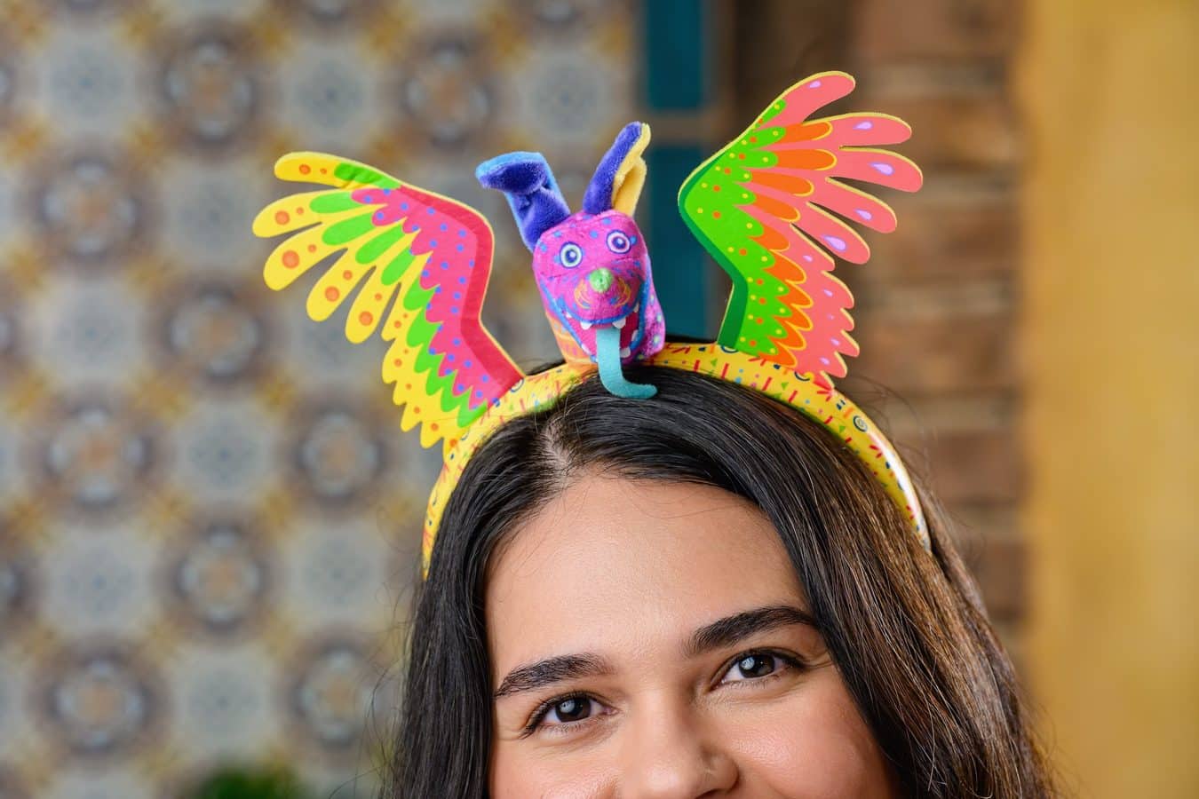Close up of a person wearing a bright multicolored butterfly headband on the head with eyes and forehead visible