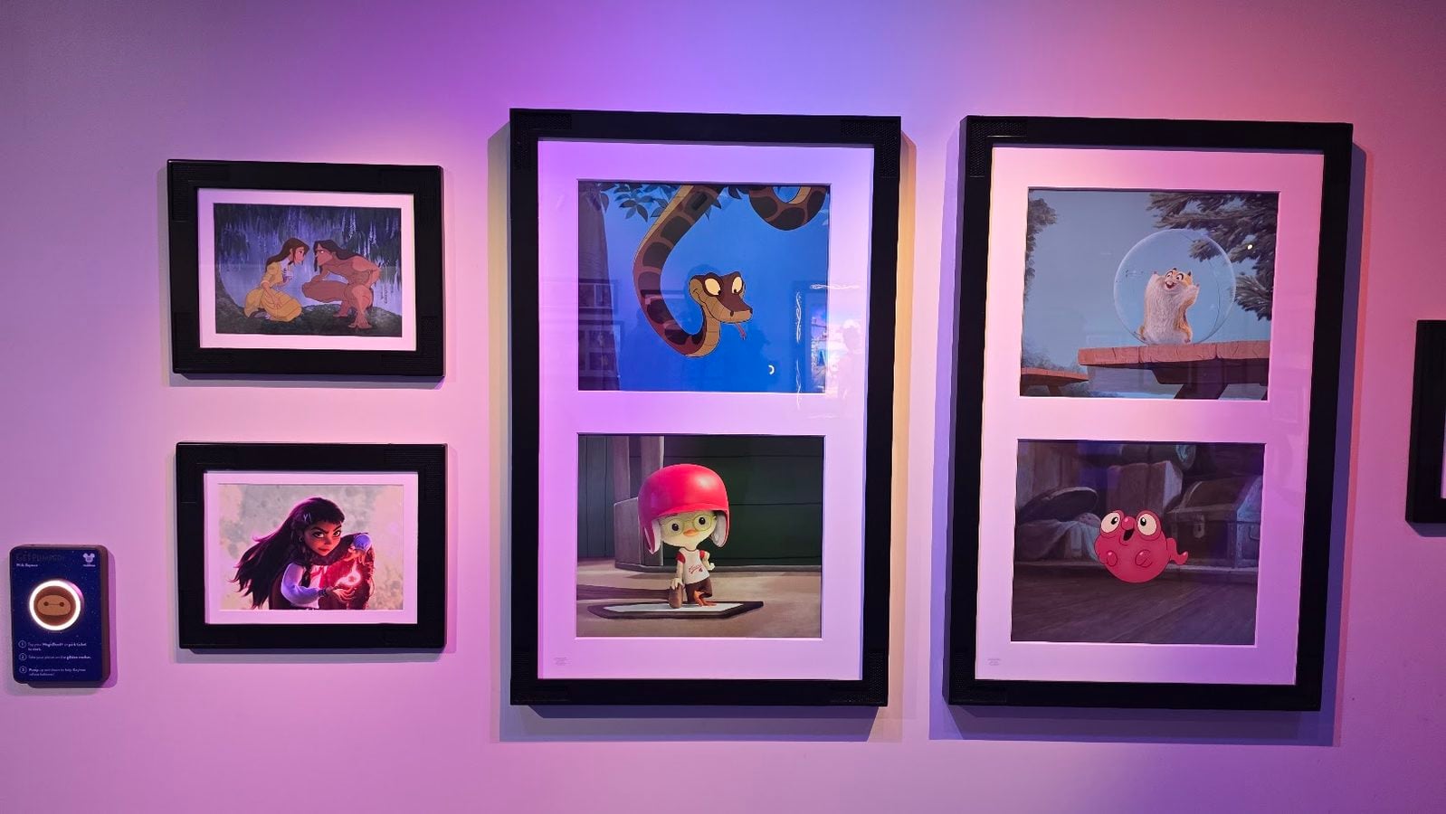Wall display of six framed animated illustrations on a purple lit wall arranged in two columns of frames with a large center grouping