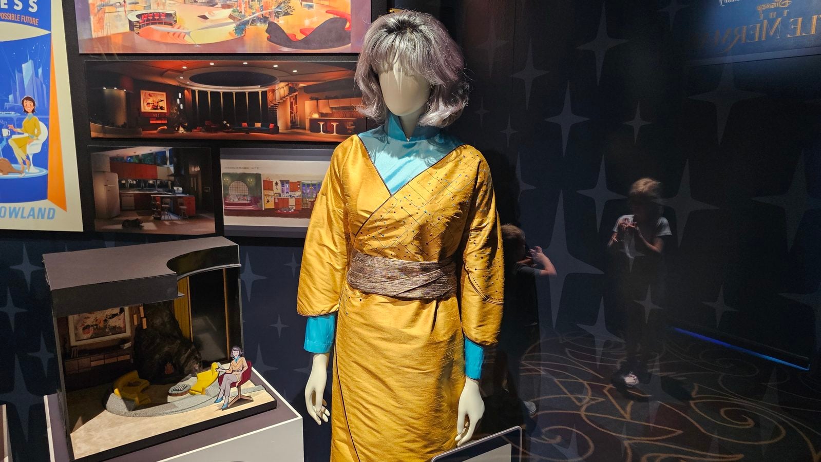 Mannequin wearing a yellow kimono with turquoise sleeves on display in a museum exhibit