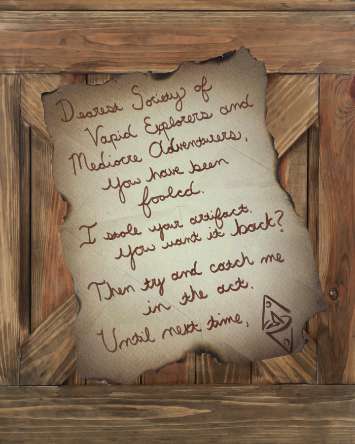 Torn parchment note with cursive handwriting on a wooden background a taunting message about stealing an artifact with a small triangular doodle in the bottom corner