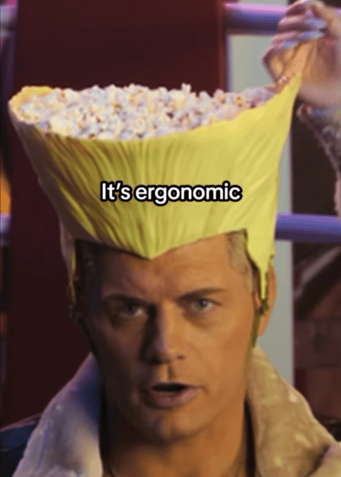 Person wearing a popcorn bucket as a hat with the caption Its ergonomic in a meme style image