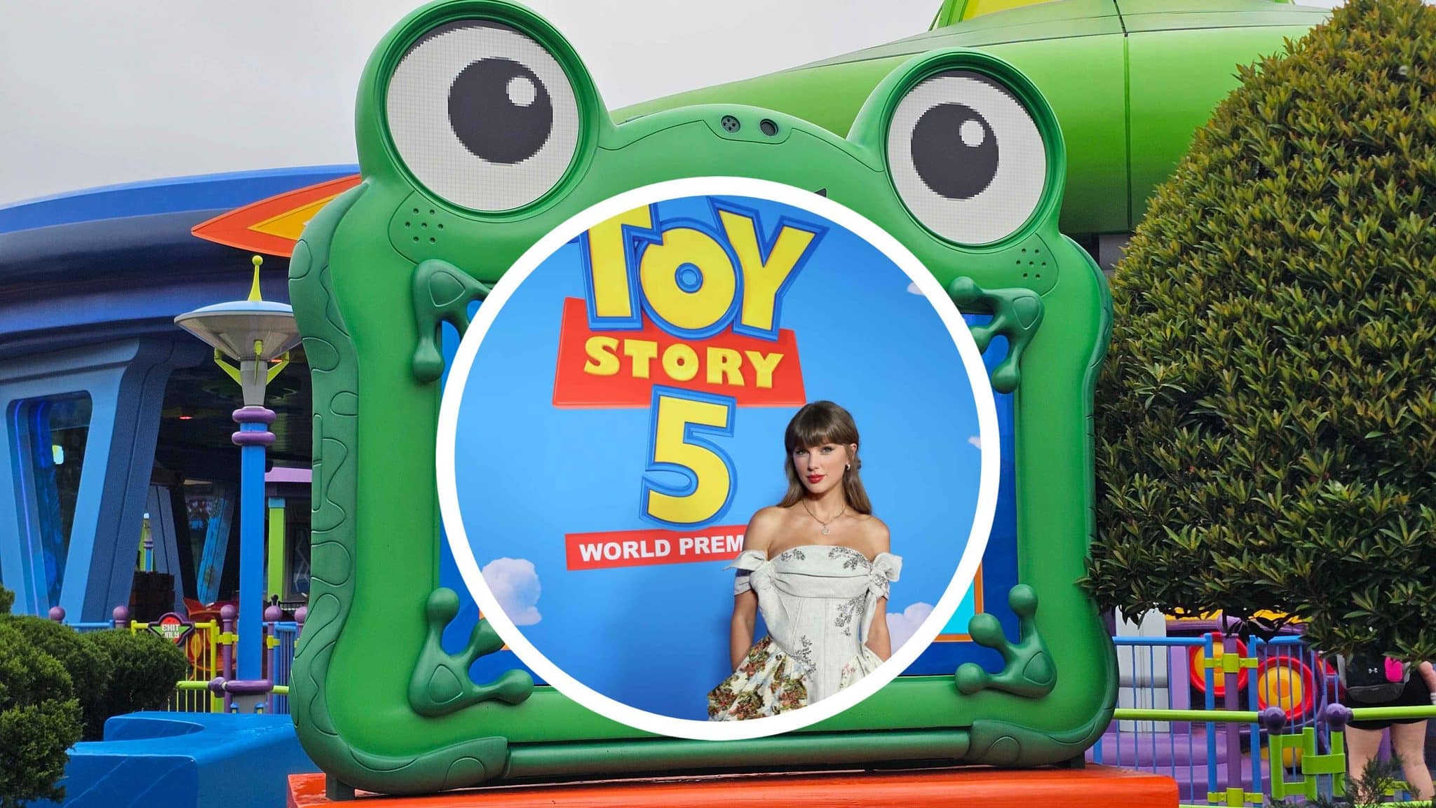 Green frog-shaped ride entrance with a circular poster for Toy Story 5 World Premiere and a woman in a white dress standing in front.