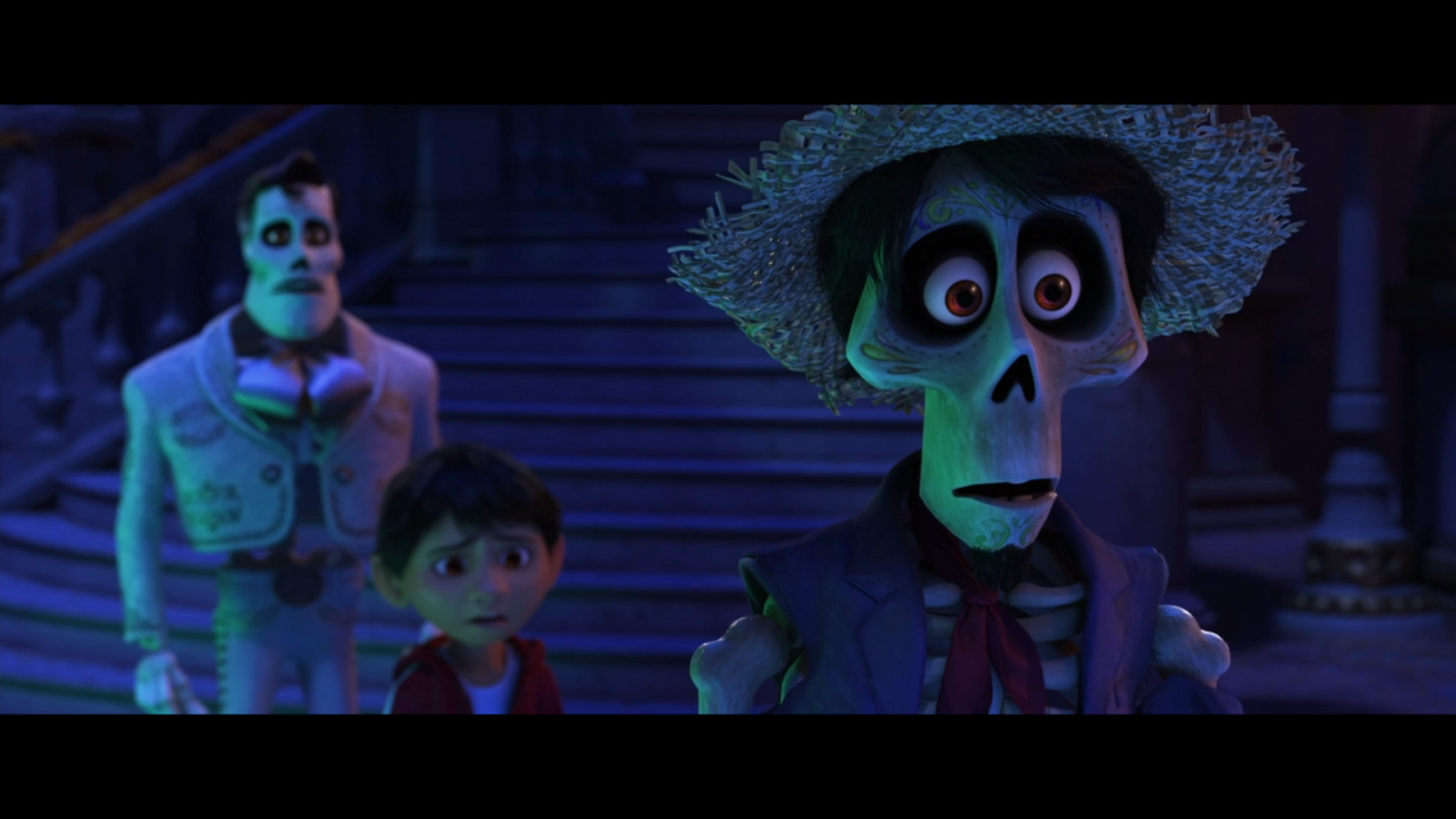 Three animated skeletons in a blue lit scene a man with a straw hat a tall figure in a coat and a small boy on steps