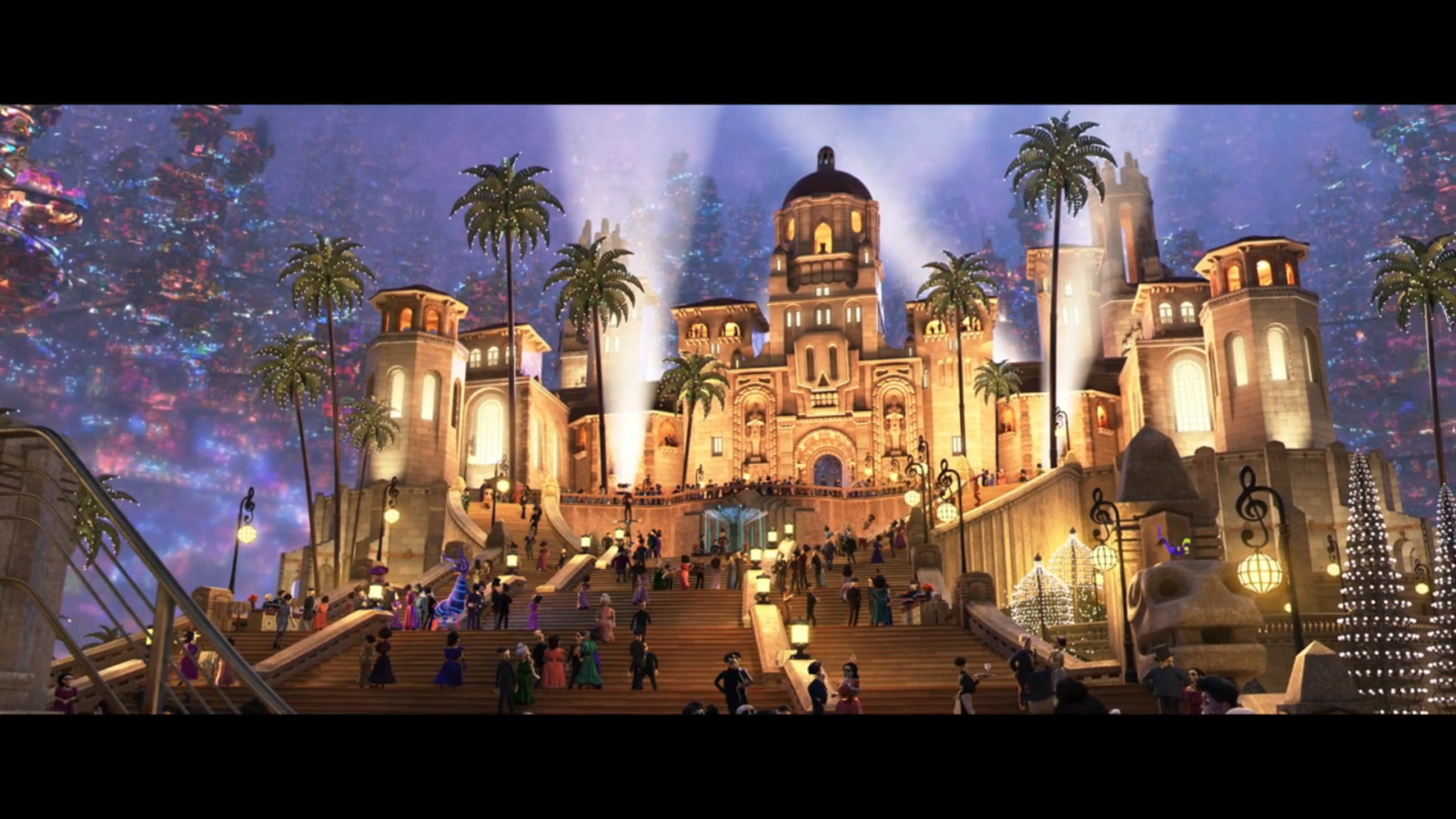 Luxurious illuminated castle like building with domes on a grand staircase palm trees and crowds at a festive evening event