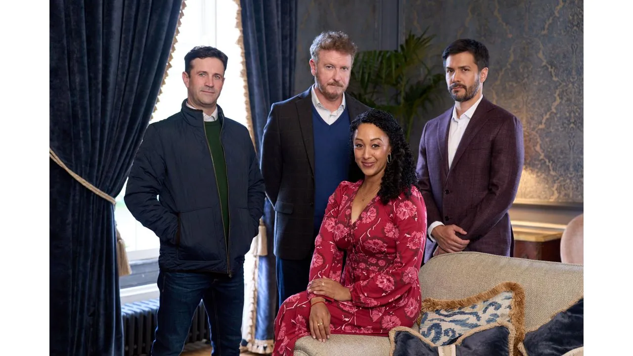 hhm7 Fantasy Land News Four adults pose for a group portrait in a luxurious living room a woman in a pink floral dress sits on a beige sofa with three men standing behind her in jackets