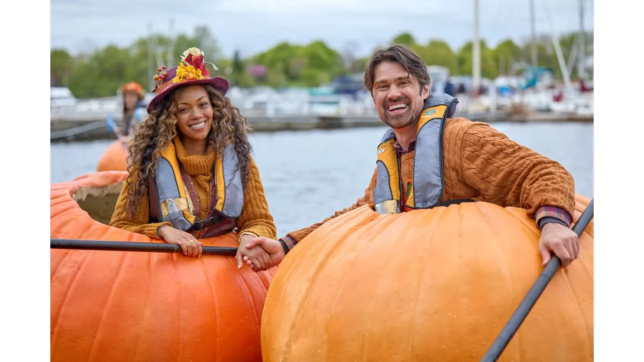 prr2 Fantasy Land News Two people wearing life jackets smile and high five across a giant pumpkin shaped float by a marina