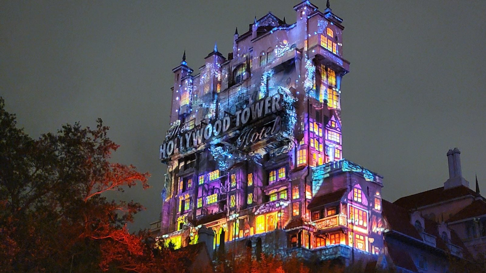 Night view of the Hollywood Tower Hotel facade illuminated with colorful projection lights at dusknight